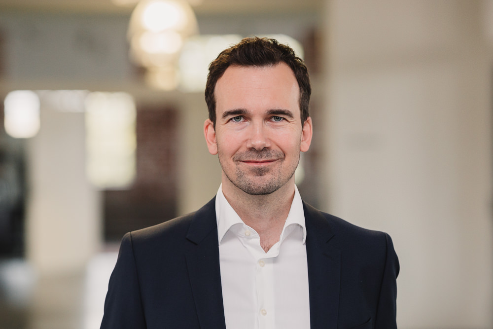 Businessportrait Mann dunkles Haar Büro hell