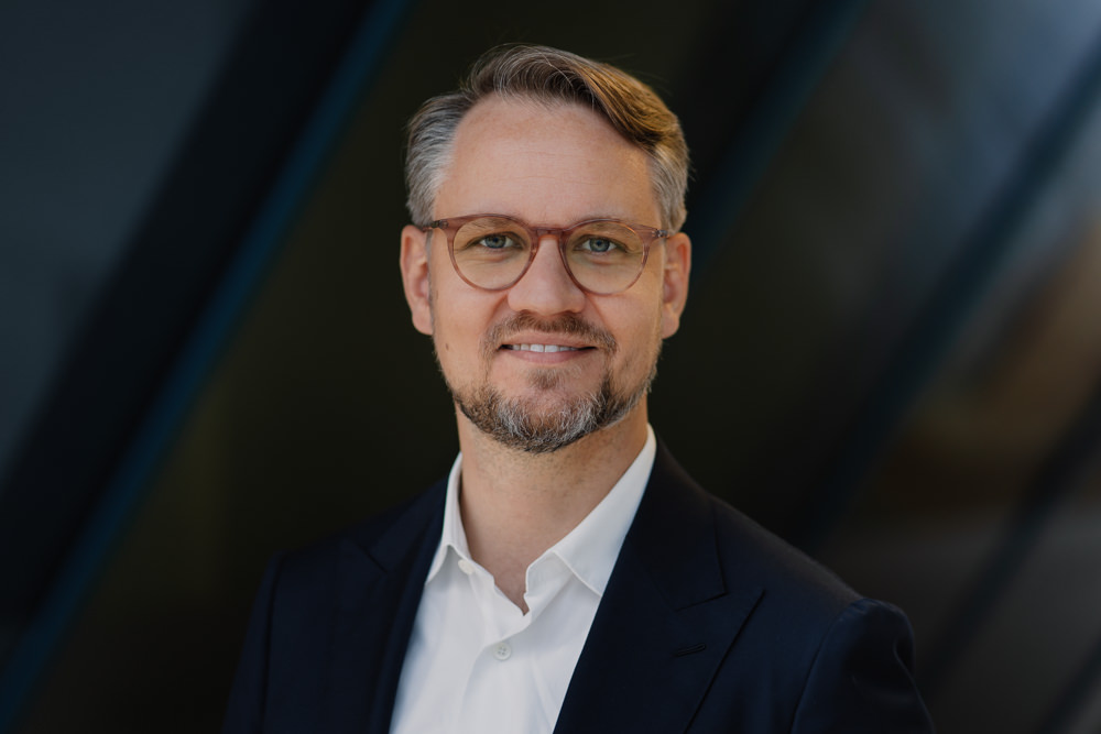 Businessportrait Mann Brille grauer Hintergrund