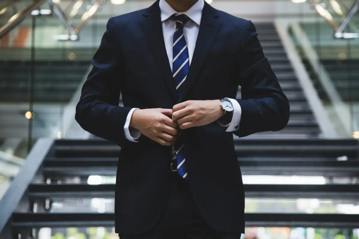 Businessmann im Anzug steht vor einer Treppe