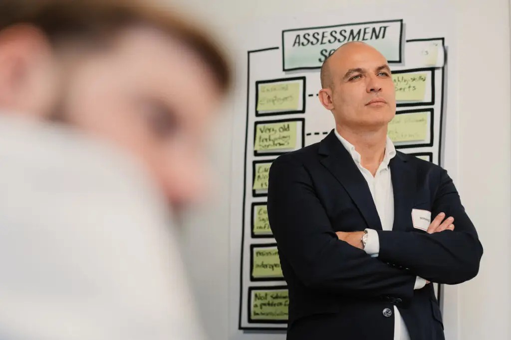 Mann verschränkte Arme vor Flipchart Präsentation